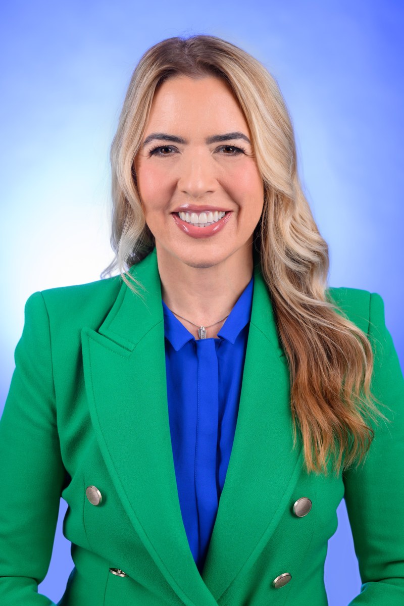 Commissioner Raquel Regalado smiling in a green blazer